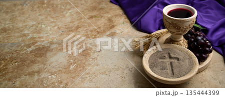 Ash wednesday cross on ashes with chalice and grapes Ash wednesday cross on ashes with chalice and grapes 135444399