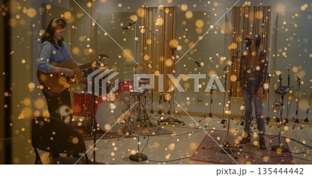 Three musicians jamming together in recording studio, with acoustic guitar and drum kit Three musicians jamming together in recording studio, with acoustic guitar and drum kit 135444442