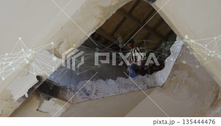 Climbing man gripping beam amid debris in damaged ceiling, with digital network overlay, copy space Climbing man gripping beam amid debris in damaged ceiling, with digital network overlay, copy space 135444476