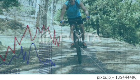 Lifting mountain bike front wheel, male cyclist riding forest trail with gloves and hydration pack Lifting mountain bike front wheel, male cyclist riding forest trail with gloves and hydration pack 135444496