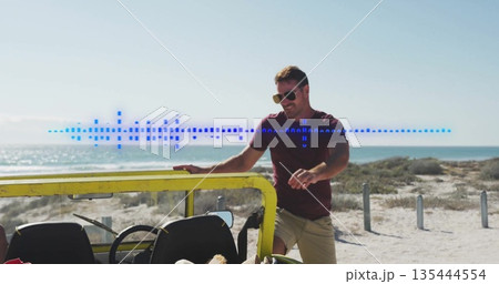Man wearing aviator sunglasses holding door frame beside sandy shore with yellow jeep, copy space Man wearing aviator sunglasses holding door frame beside sandy shore with yellow jeep, copy space 135444554
