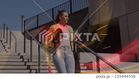 Walking woman descending concrete stairs at building exterior, with straw hat and bag, copy space 135444556