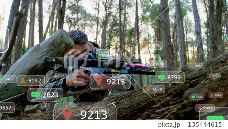 Aiming soldier in camouflage vest lying behind log in pine forest, with scoped rifle, AR overlays Aiming soldier in camouflage vest lying behind log in pine forest, with scoped rifle, AR overlays 135444615