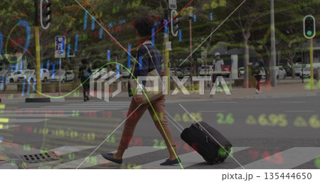 Crossing woman pulling suitcase and carrying tote bag on urban zebra crossing, stock market overlay 135444650