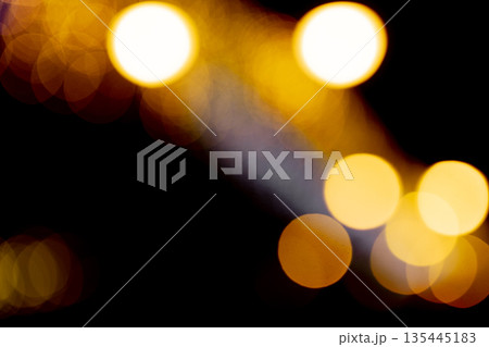 Golden blurred bokeh lights on black background with soft glowing circles, abstract festive night 135445183
