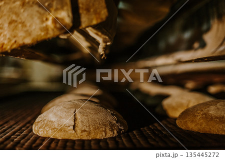 Fresh buns from the oven. Conveyor with bread. Baking bread. Workshop for production of bread. White bread in the oven. Hot buns. Confectionery. 135445272