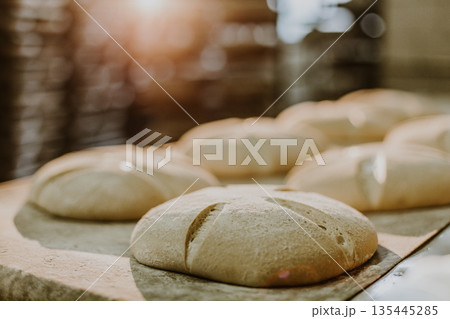 Dessert bread baking in oven. Production oven at the bakery. Baking bread. Manufacture of bread. Dessert bread baking in oven. Production oven at the bakery. Baking bread. Manufacture of bread. 135445285