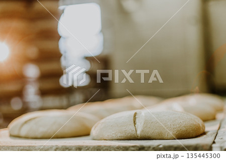 Dessert bread baking in oven. Production oven at the bakery. Baking bread. Manufacture of bread. 135445300