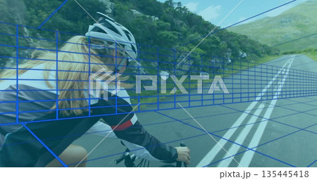 Riding female cyclist on road bicycle on winding mountain road with double white lines, copy space Riding female cyclist on road bicycle on winding mountain road with double white lines, copy space 135445418