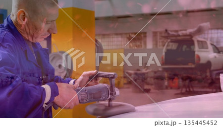 Buffing mechanic in blue coverall polishing car hood in garage, with buffer and SUV, copy space 135445452