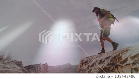 Adult male hiker wearing wide-brimmed hat stepping across canyon ledge, with backpack, copy space Adult male hiker wearing wide-brimmed hat stepping across canyon ledge, with backpack, copy space 135445486