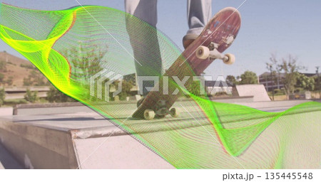 Balancing skateboarder on concrete ramp holding skateboard wearing skate shoes, with green overlay Balancing skateboarder on concrete ramp holding skateboard wearing skate shoes, with green overlay 135445548