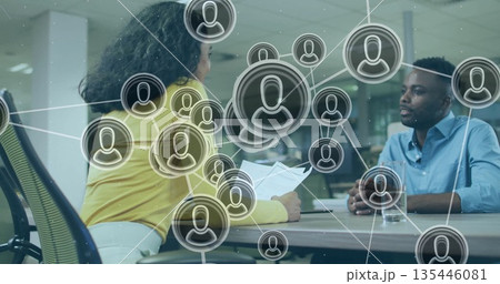 Female interviewer holding papers and questioning candidate in conference room, with network icons Female interviewer holding papers and questioning candidate in conference room, with network icons 135446081