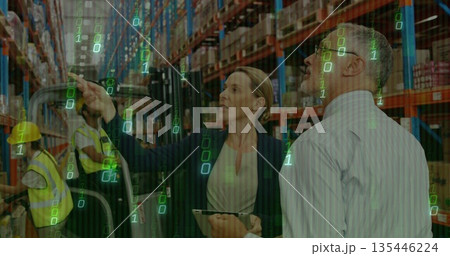 Businesswoman pointing at stock and using tablet in warehouse with forklift pallet jack operating Businesswoman pointing at stock and using tablet in warehouse with forklift pallet jack operating 135446224