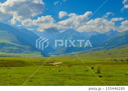 Majestic mountain landscape with rolling green hills and clouds in Kyrgyzstan Majestic mountain landscape with rolling green hills and clouds in Kyrgyzstan 135446280