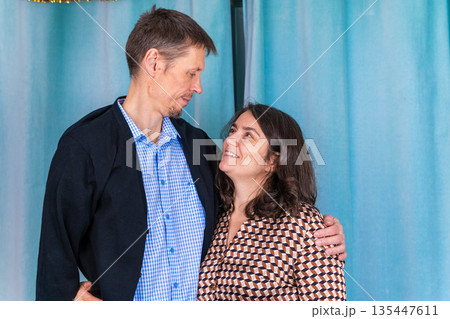 Couple smiling at each other during indoor gathering in casual clothing 135447611