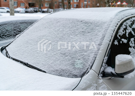 Snow covers a parked car in a residential area during winter season Snow covers a parked car in a residential area during winter season 135447620