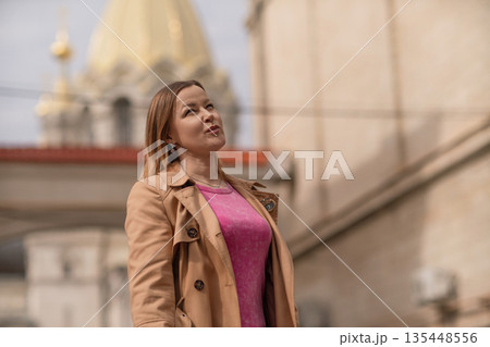 Woman Church Dome: Woman looks up at church dome during daytime in city, for sightseeing. Woman Church Dome: Woman looks up at church dome during daytime in city, for sightseeing. 135448556
