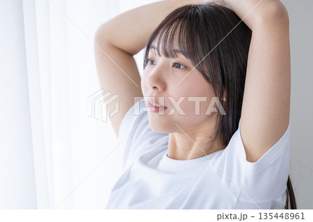 窓辺でストレッチをする若い女性 135448961