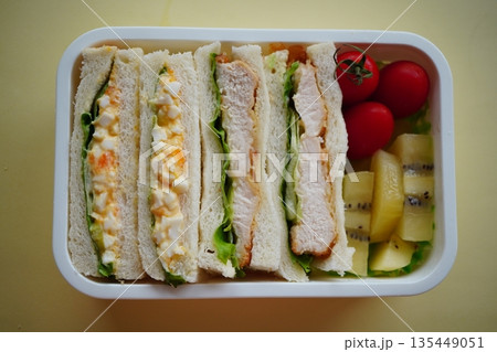卵とチキンのサンドイッチ弁当、フルーツ付きで満足感のあるランチボックス写真 卵とチキンのサンドイッチ弁当、フルーツ付きで満足感のあるランチボックス写真 135449051