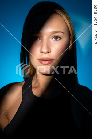 Beauty portrait of a girl with a beautiful shadow pattern in the studio. 135449080
