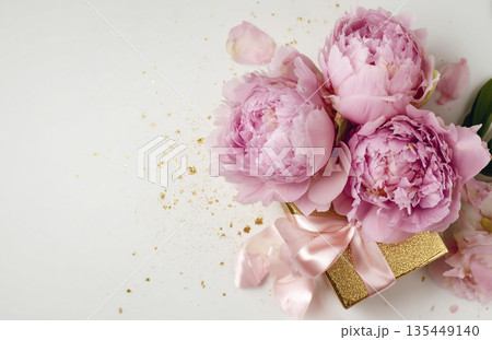 Gift box with pink peonies and gold decorations on a white background 135449140