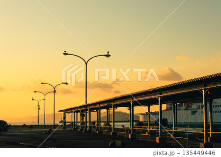 愛媛県八幡浜市の八幡浜港で、夕暮れ時の街灯と穏やかな海とフェリー 135449446