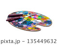 Isolated object for creativity. Oval wooden artist palette covered with colorful spots of dry and fresh paint, featuring two palette knives. Concept of art, hobby, painting, and inspiration 135449632