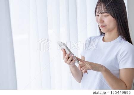 スマートフォンを持つ若い女性 135449696