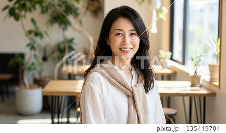 カフェで笑顔で話をする40代の女性 135449704