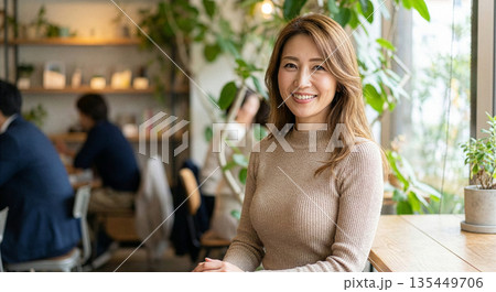 カフェで笑顔で話をする40代の女性 135449706