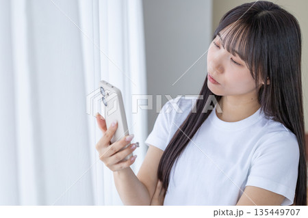 スマートフォンを持って考える若い女性 スマートフォンを持って考える若い女性 135449707