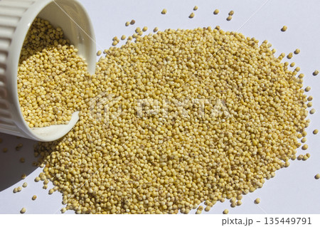 This is a scene of pouring out millet rice from a bowl. 135449791
