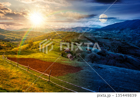 scenic view of arable and wooden fence on hills in rural area. day and night time change concept. beautiful countryside mountain landscape in spring with sun and moon. duality and transition template scenic view of arable and wooden fence on hills in rural area. day and night time change concept. beautiful countryside mountain landscape in spring with sun and moon. duality and transition template 135449839