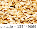 Macro shot of a pile of peeled pistachio nut shells. Organic background showing detail, natural beige color, and food waste texture. Concept of recycling, healthy snacking, and natural material 135449869