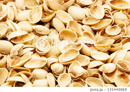 Macro shot of a pile of peeled pistachio nut shells. Organic background showing detail, natural beige color, and food waste texture. Concept of recycling, healthy snacking, and natural material 135449869