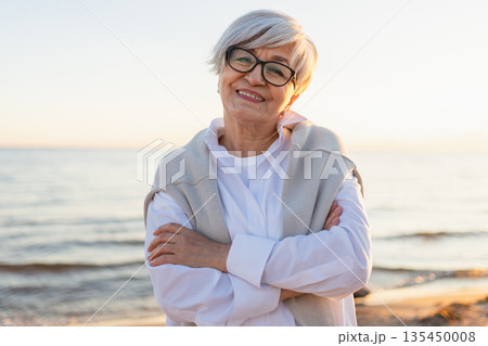 Outdoor portrait of confident stylish European middle aged senior woman. Older mature lady smiling on beach. Happy attractive senior female looking camera close up face headshot portrait. Happy people Outdoor portrait of confident stylish European middle aged senior woman. Older mature lady smiling on beach. Happy attractive senior female looking camera close up face headshot portrait. Happy people 135450008