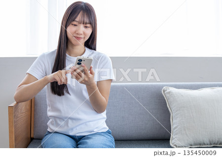 スマートフォンを使う若い女性 スマートフォンを使う若い女性 135450009