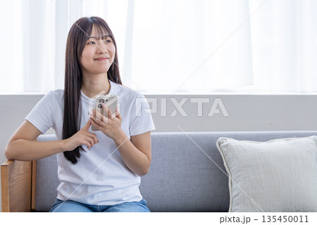 スマートフォンを使う若い女性 スマートフォンを使う若い女性 135450011
