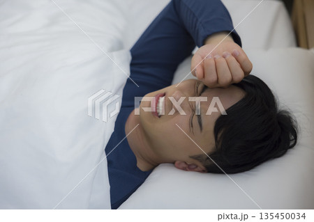 ベッドで眠る男性　 135450034