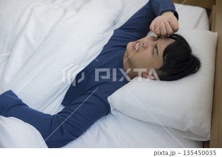 ベッドで眠る男性　 135450035