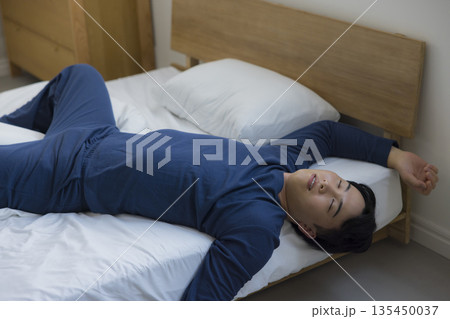 ベッドで眠る男性　 135450037
