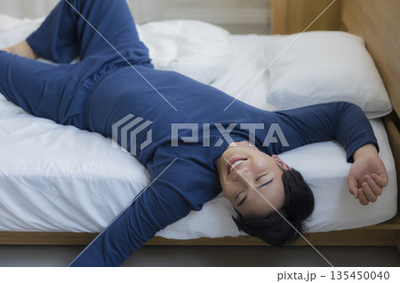 ベッドで眠る男性　 135450040