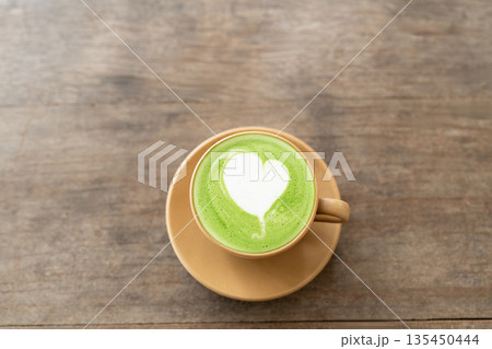 Matcha green tea with heart latte art on grunge wooden table Matcha green tea with heart latte art on grunge wooden table 135450444