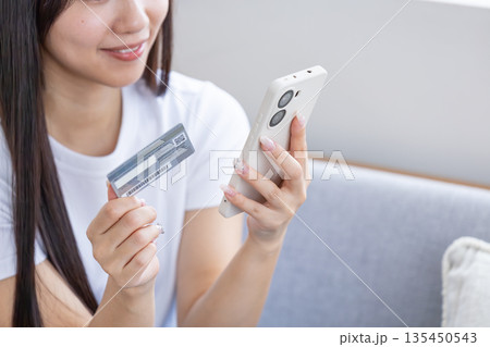 スマホとクレジットカードを持つ若い女性 スマホとクレジットカードを持つ若い女性 135450543