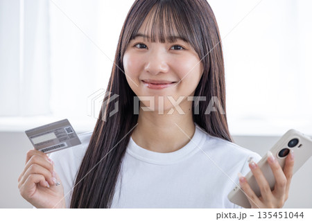 スマホとクレジットカードを持つ若い女性 スマホとクレジットカードを持つ若い女性 135451044