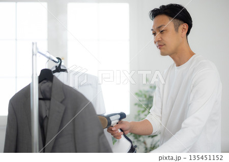 服にスチーマーをかける男性 服にスチーマーをかける男性 135451152