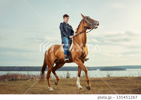 A man riding a horse outdoors 135451267