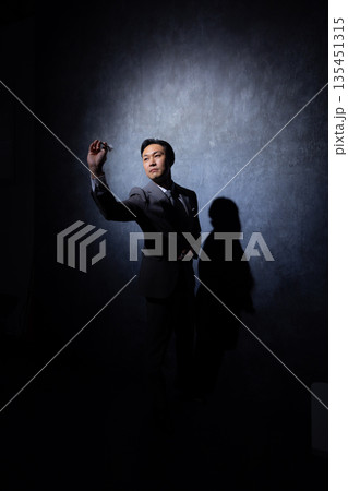 暗い背景のビジネスマン　 135451315