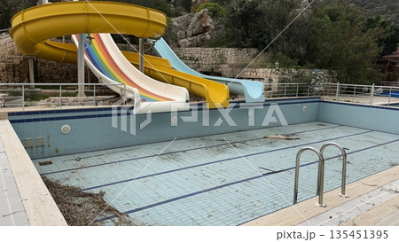Empty pool with colorful water slides in outdoor setting, suitable for background or concept themes Empty pool with colorful water slides in outdoor setting, suitable for background or concept themes 135451395